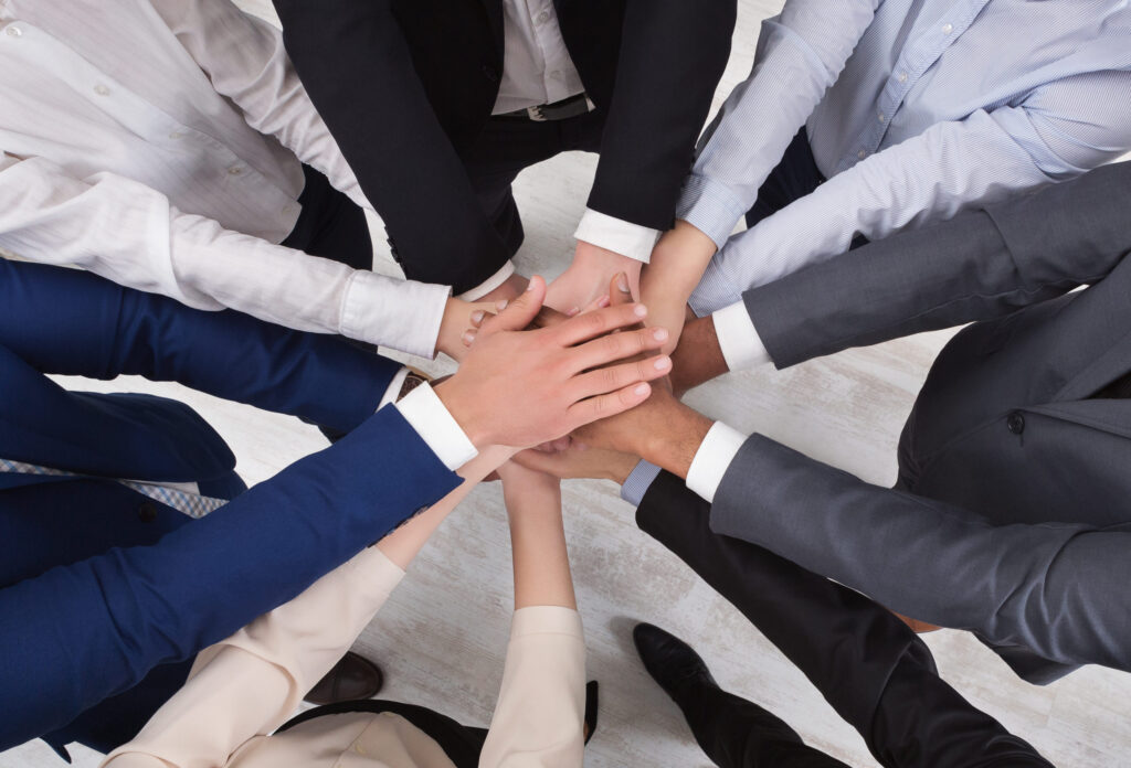 Top view of people putting their hands together in circle formation