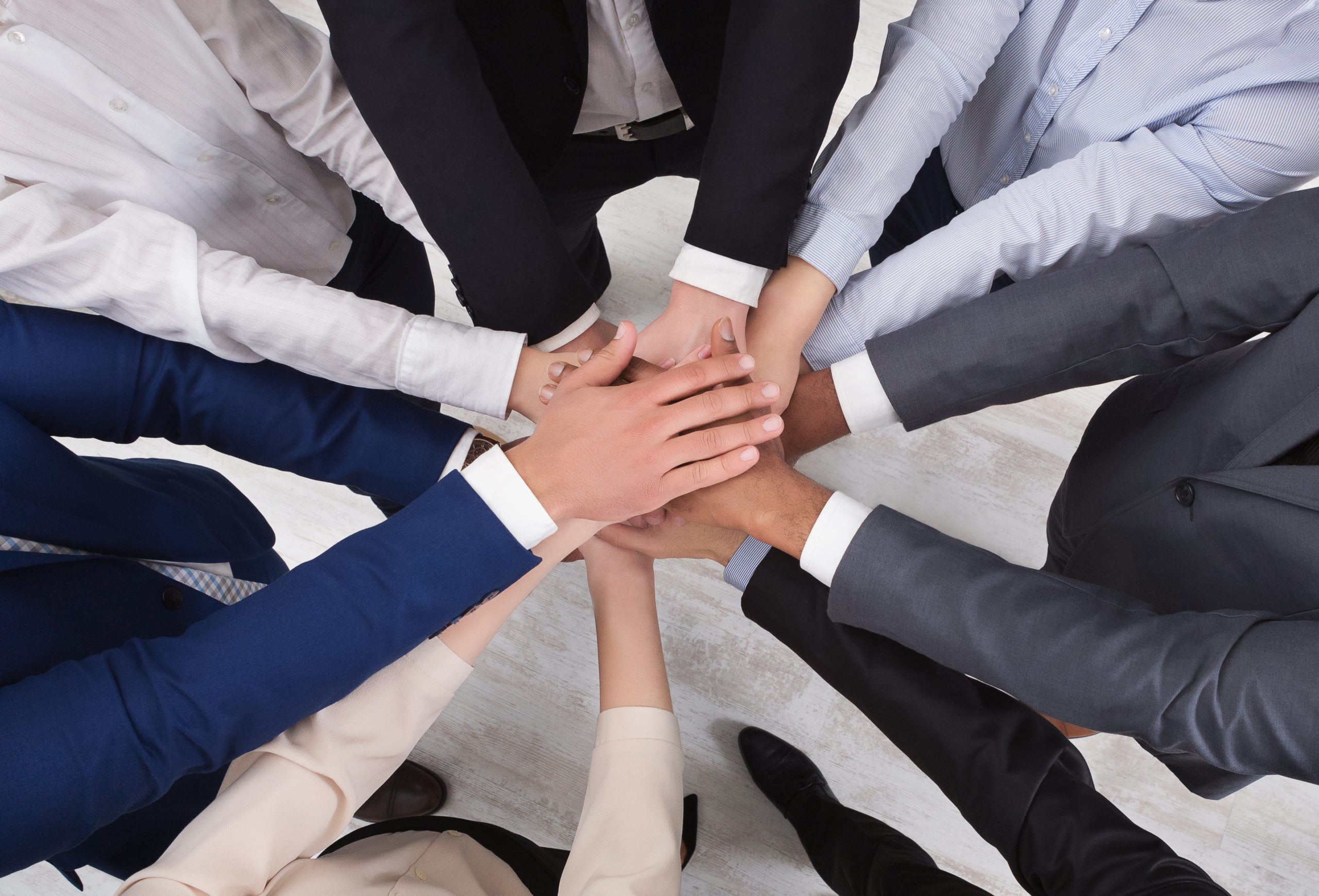 Top view of people putting their hands together in circle formation