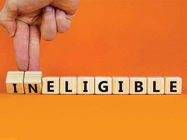Wooden letter tiles spelling INELIGIBLE on an orange background
