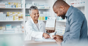 Female pharmacist pointing to paper male signing paper