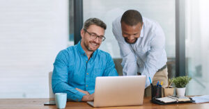 Two people looking at laptop smiling