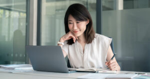 Woman smiling at computer screen
