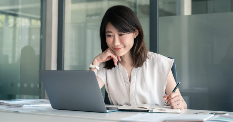 Woman smiling at computer screen