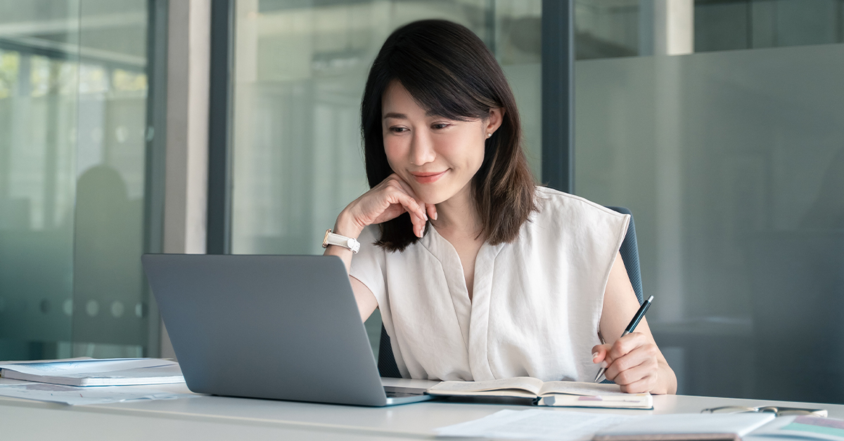 Woman smiling at computer screen