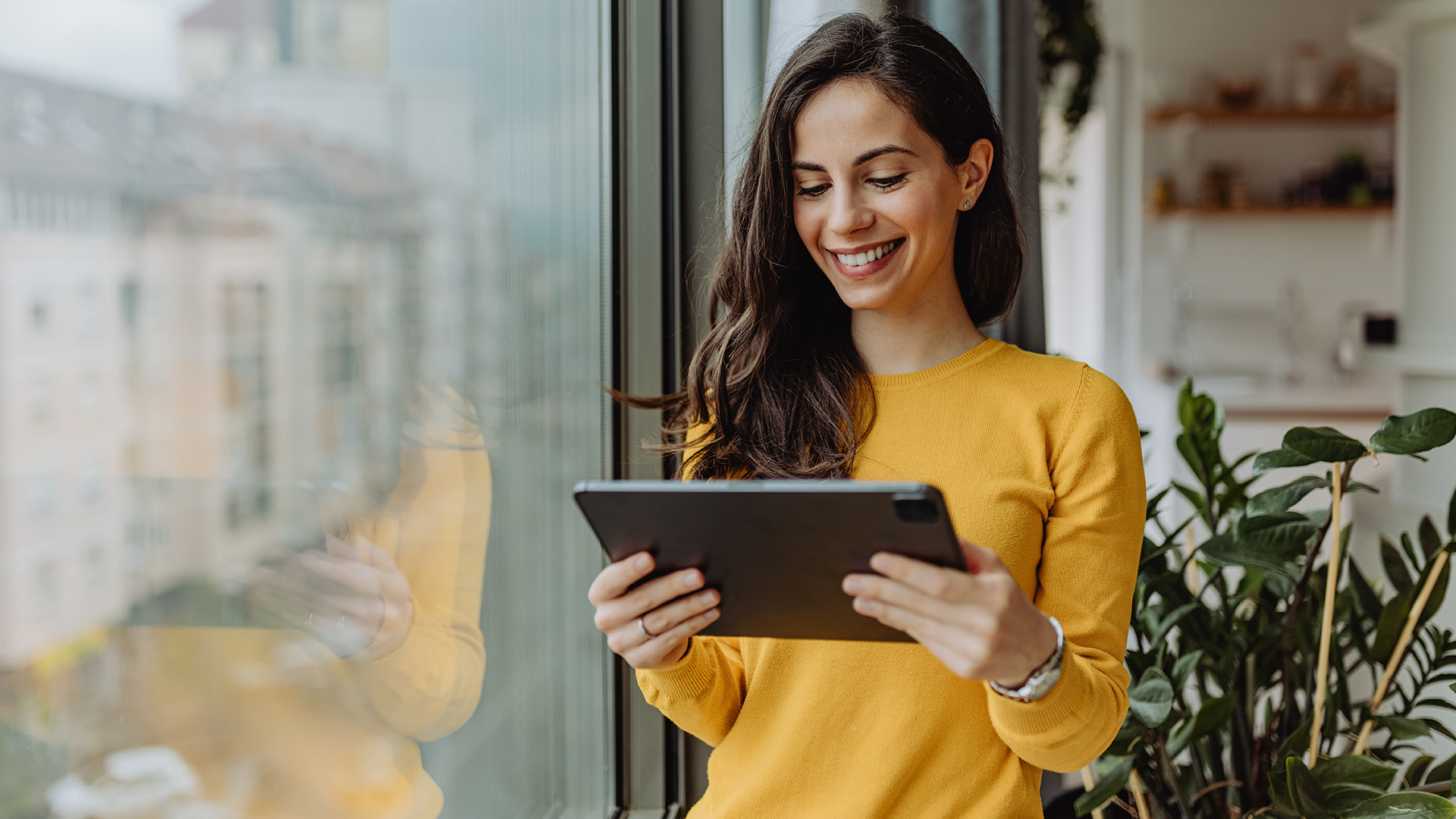 Woman looking at a tablet smiling