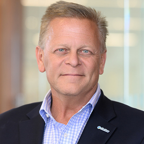 Professional headshot of an older man with gray hair in a blue suit