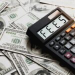 $20 dollar bills and a calculator that says fees