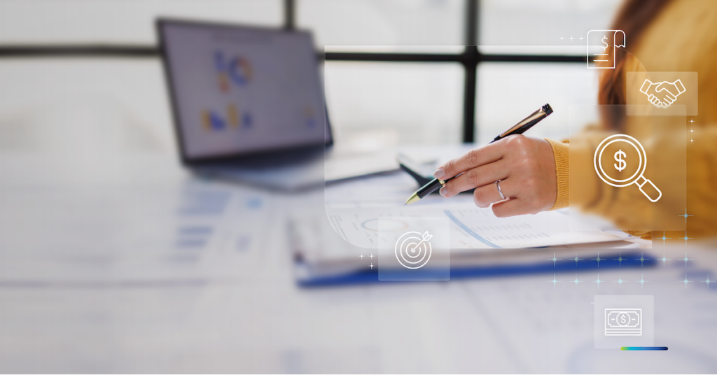 Woman at desk writing notes while referencing tablet
